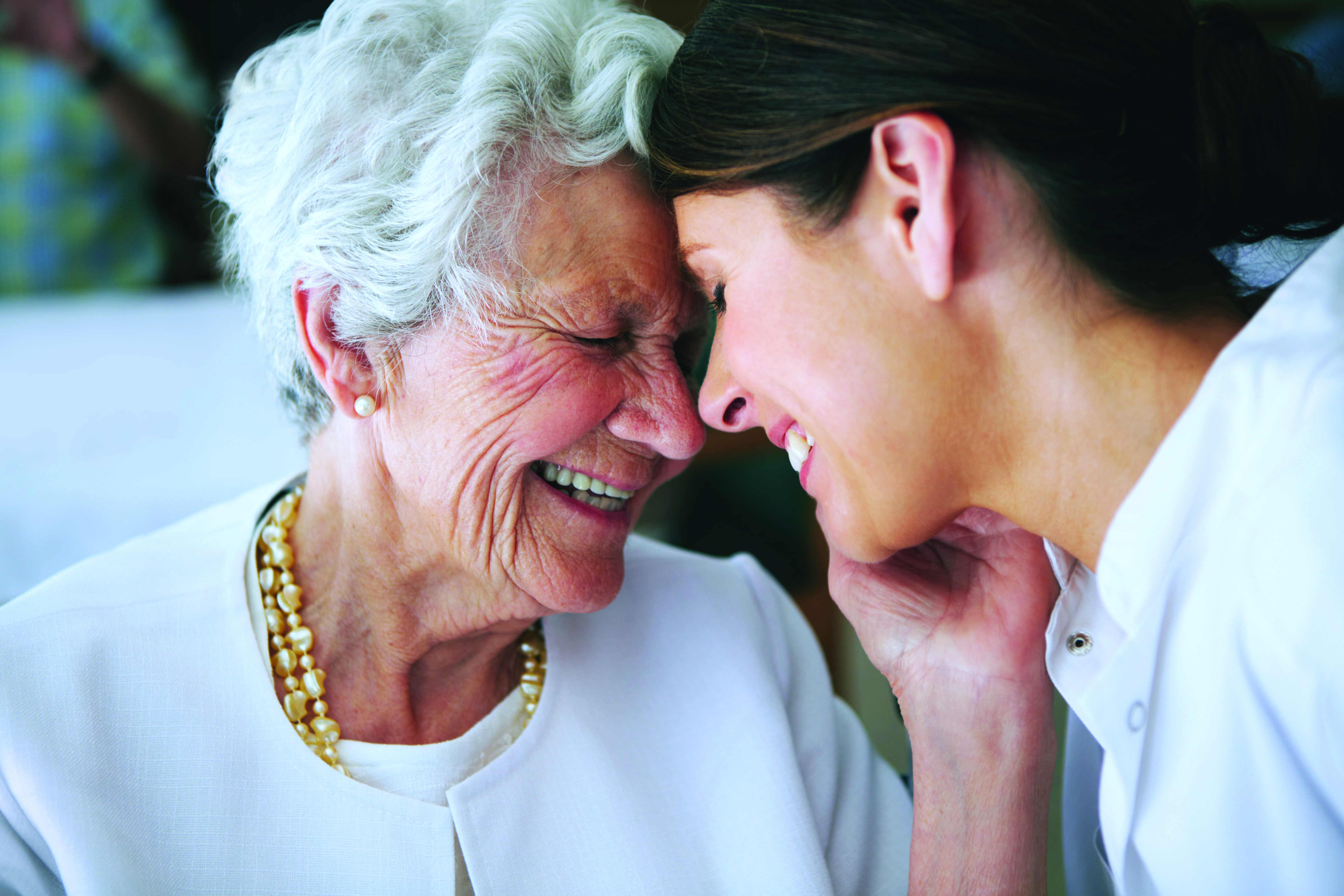 An elderly woman affectionately thanking her nurse