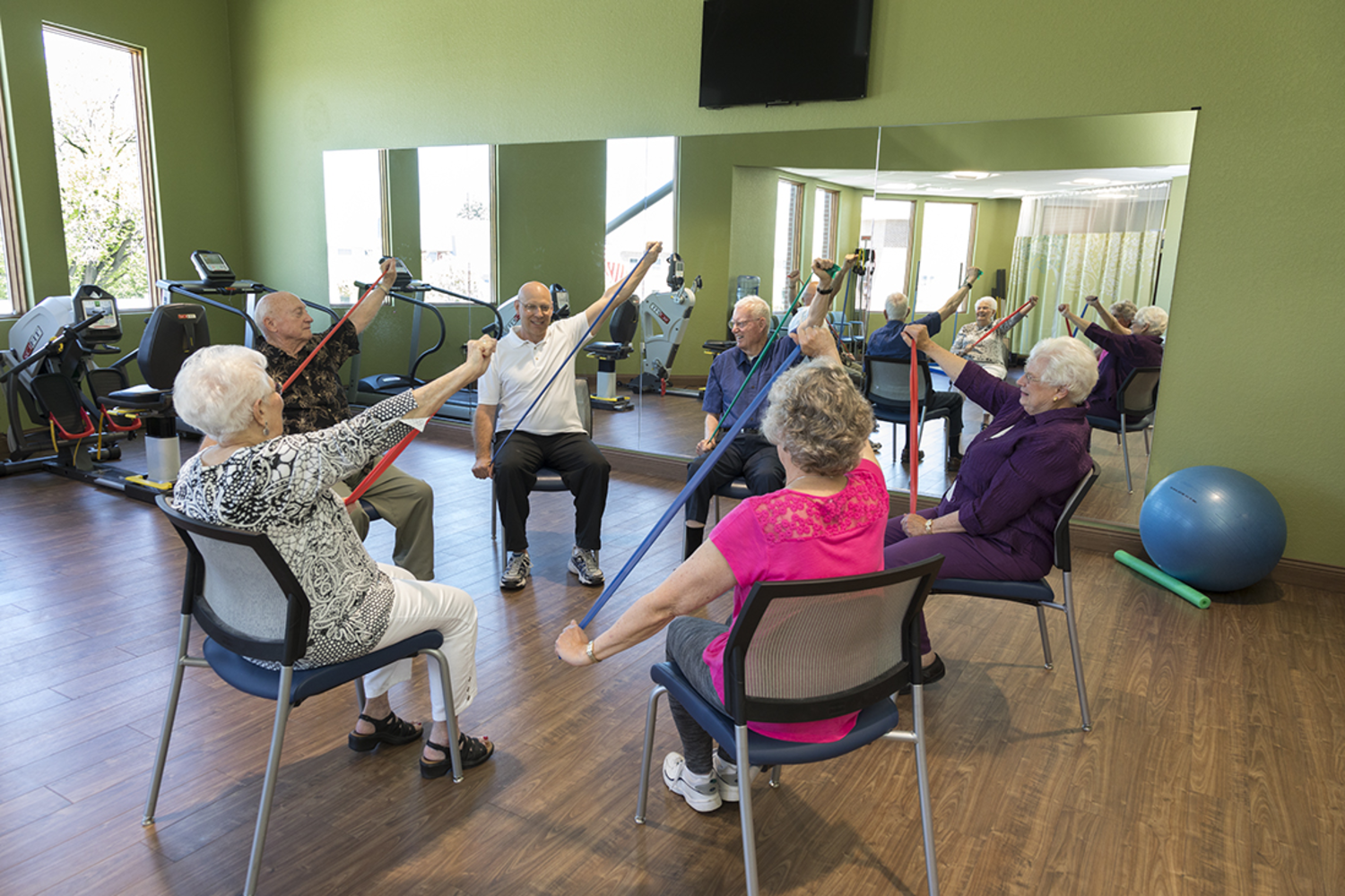 A group of older residents participates in a low-impact stretching exercise class at Rosemark at Mayfair Park